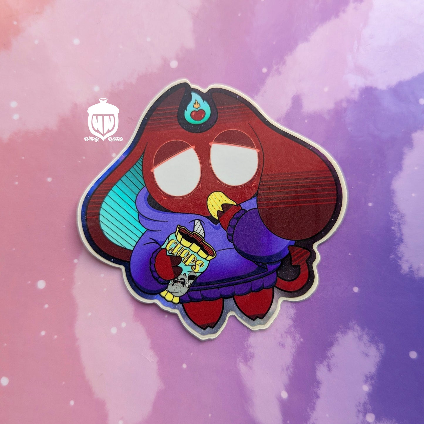 A photograph of a vinyl sticker against a pink and purple background. The sticker features Jack, the lazy demon. The sticker is approx 3 by 3 inches and is made of super durable waterproof vinyl.
