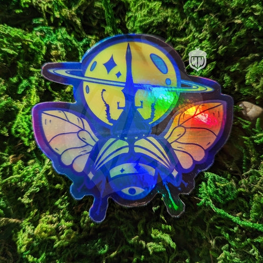Photograph of a mossy background with a holographic vinyl sticker a hercules beetle with a saturn theme.
